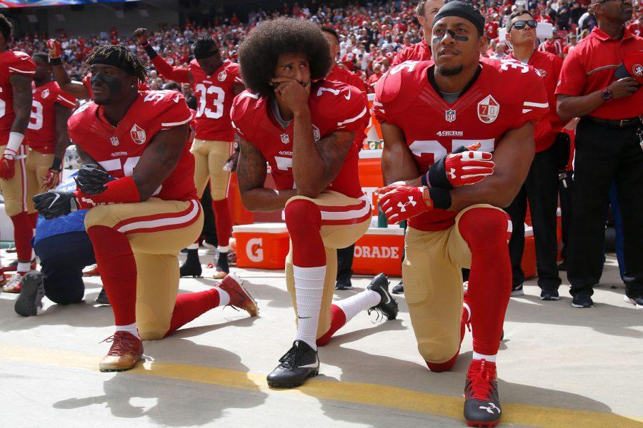 Eli Harold, Colin Kaepernick and Eric Reed kneel during the national anthem on Oct. 2.